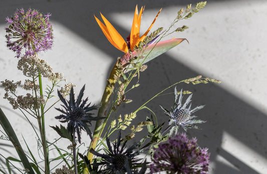 A minimalist bouquet of flowers in muted colours like green, lila and orange. From slow fashion brand Daniela Salazar.