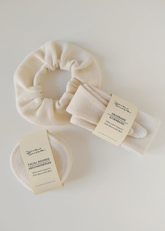 a headband, reusable face pads and a scrunchie. All of the made in textured ivory organic cotton