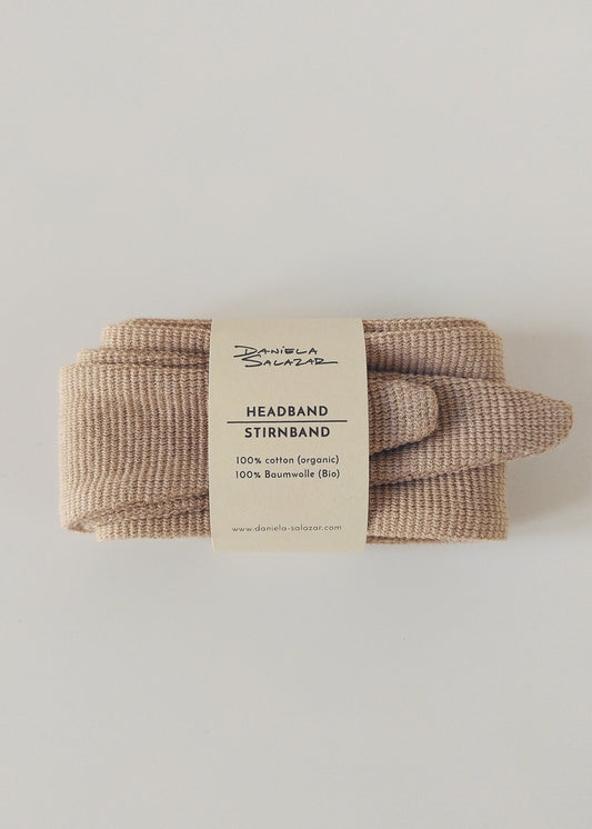 A brown organic cotton headband labeled 'Headband / Stirnband' with a textured fabric, displayed on a white background.