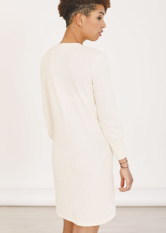 Back of the organic cotton dress Tana in ivory colour. Detail of the back seam, long sleeves with slight peasant shape and long cuffs